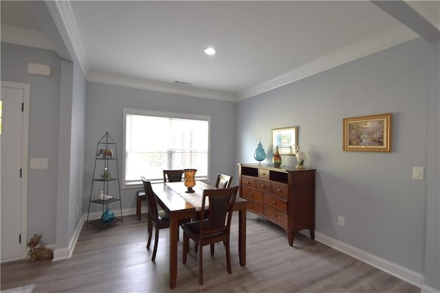 dining space featuring crown molding and light hardwood / wood-style floors