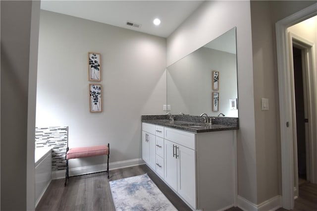 bathroom featuring decorative backsplash, wood-type flooring, and vanity