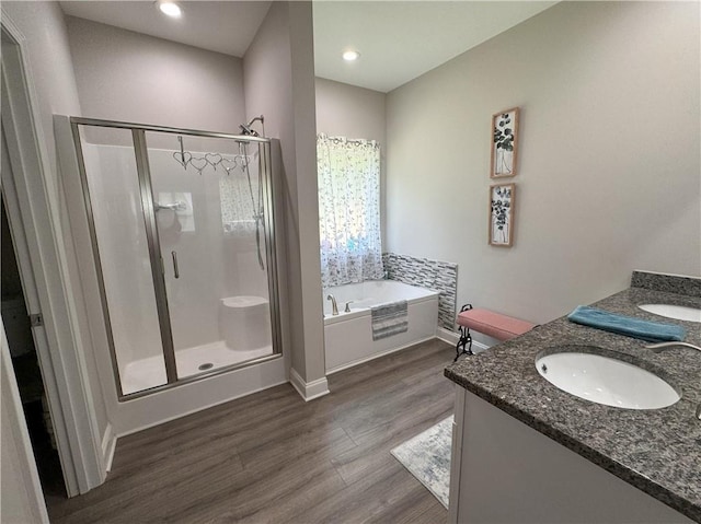 bathroom featuring hardwood / wood-style flooring, vanity, and plus walk in shower