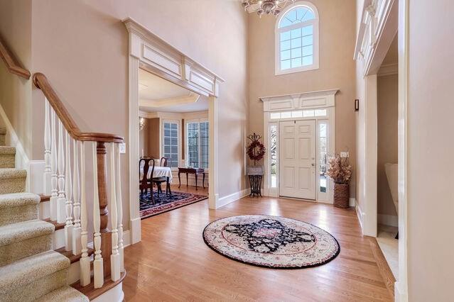 foyer entrance with a chandelier, a high ceiling, and light hardwood / wood-style flooring