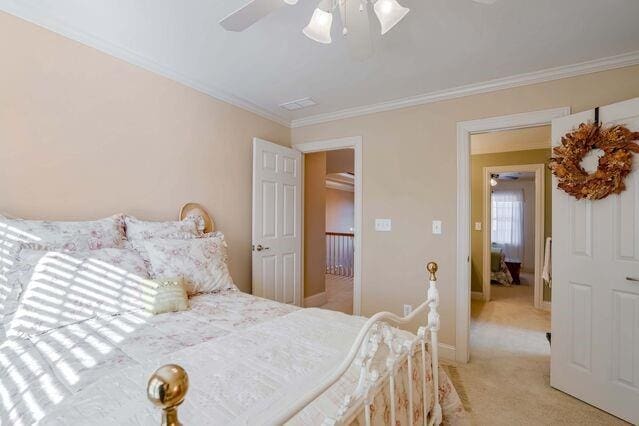 carpeted bedroom with ceiling fan and crown molding