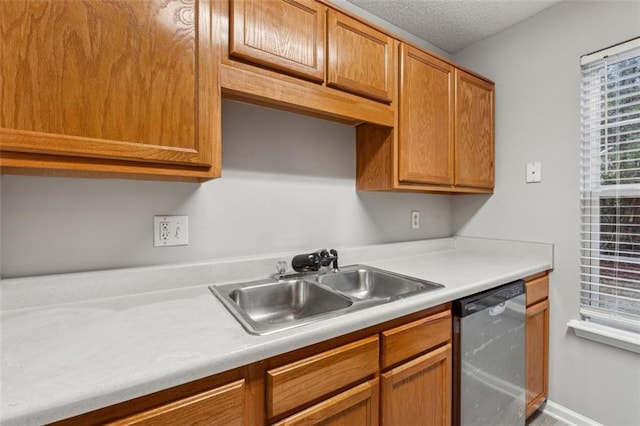 kitchen with a textured ceiling, dishwasher, and sink