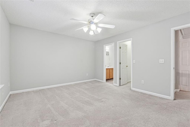 unfurnished bedroom with light carpet, a textured ceiling, connected bathroom, and ceiling fan