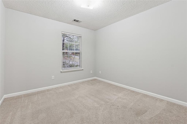 carpeted spare room featuring a textured ceiling