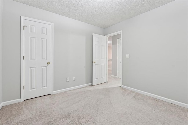 carpeted empty room featuring a textured ceiling