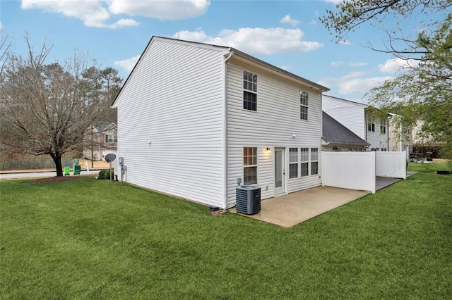 rear view of property with central AC, a patio area, and a lawn