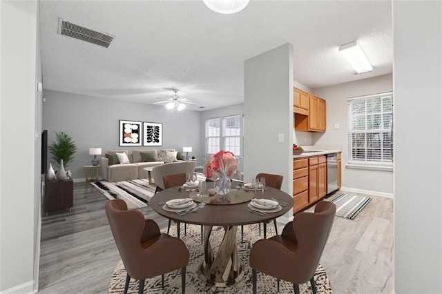 dining room featuring a wealth of natural light, ceiling fan, and light wood-type flooring