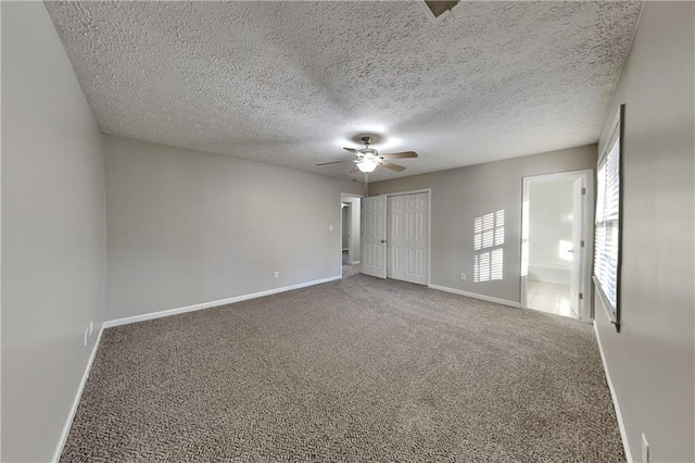 unfurnished bedroom featuring baseboards, a ceiling fan, carpet, a textured ceiling, and a closet