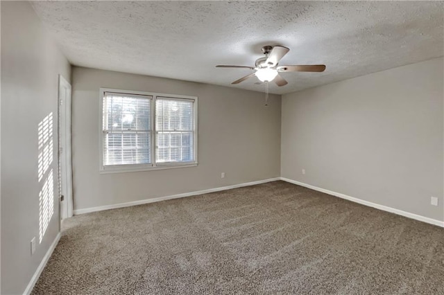 carpeted spare room with ceiling fan, baseboards, and a textured ceiling