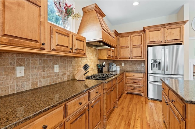 5955 Manchester Ln, Gainesville, GA 30506 - kitchen with stainless steel fridge with ice dispenser, premium range hood, black gas stovetop, light wood-style floors, and brown cabinets