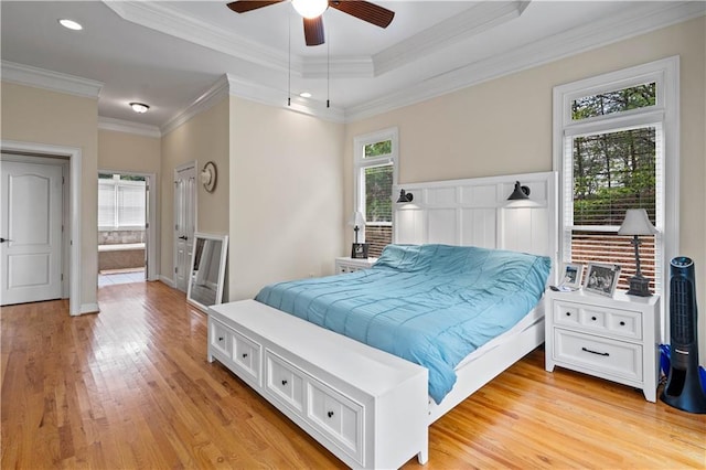 5955 Manchester Ln, Gainesville, GA 30506 - bedroom featuring light wood-type flooring, crown molding, a tray ceiling, connected bathroom, and a ceiling fan