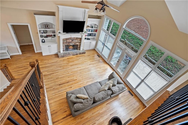 5955 Manchester Ln, Gainesville, GA 30506 - living area featuring a ceiling fan, a fireplace, light wood finished floors, a high ceiling, and baseboards
