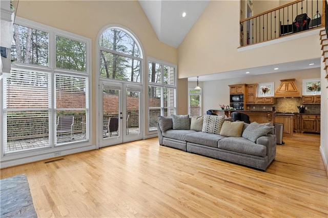 5955 Manchester Ln, Gainesville, GA 30506 - living room featuring light wood-type flooring, plenty of natural light, high vaulted ceiling, and french doors
