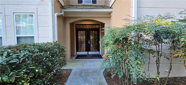 property entrance with french doors and stucco siding