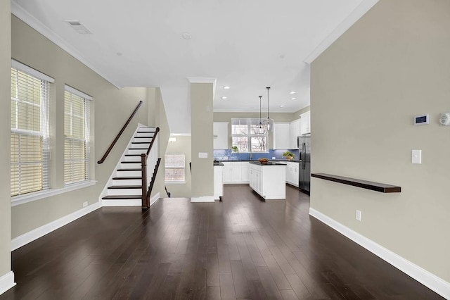 unfurnished living room featuring visible vents, baseboards, dark wood-type flooring, and stairway