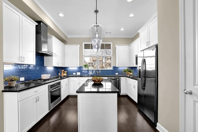 kitchen featuring dark countertops, stainless steel appliances, wall chimney exhaust hood, and ornamental molding