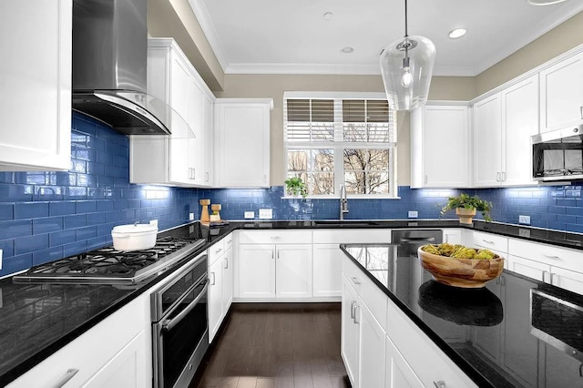 kitchen with ornamental molding, appliances with stainless steel finishes, white cabinetry, wall chimney exhaust hood, and a sink