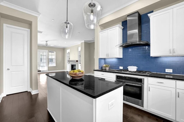 kitchen featuring dark countertops, wall chimney exhaust hood, dark wood-style floors, and appliances with stainless steel finishes