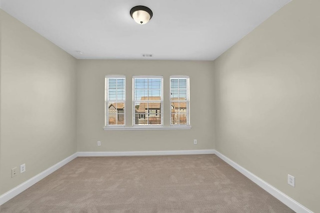 carpeted spare room with visible vents and baseboards