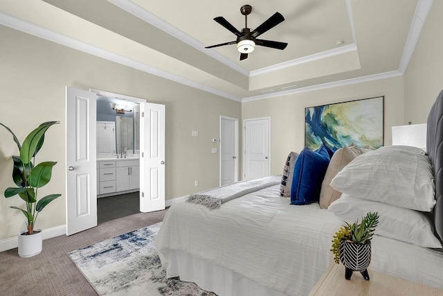 carpeted bedroom featuring a sink, a raised ceiling, baseboards, and ornamental molding