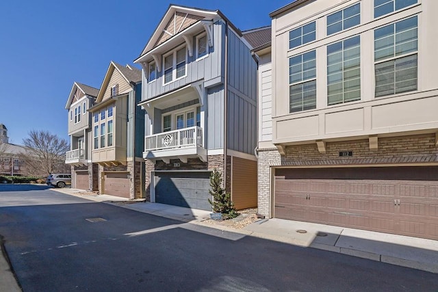 multi unit property with a garage, board and batten siding, and a residential view