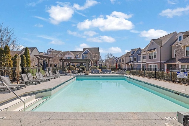 pool with a pergola, fence, a residential view, and a patio