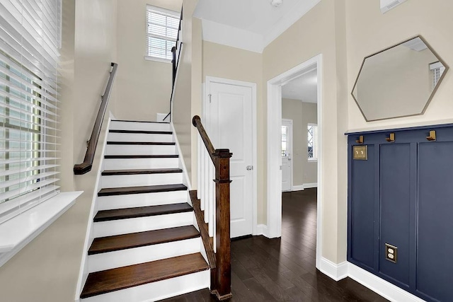 stairs with wood finished floors, a healthy amount of sunlight, and baseboards