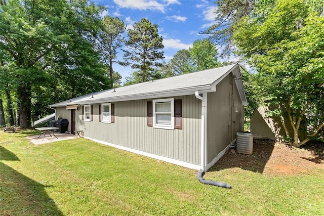 view of side of home featuring a yard, a patio, and cooling unit