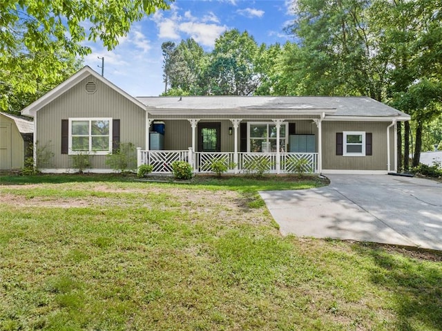 ranch-style house featuring a front lawn, a porch, and a storage shed