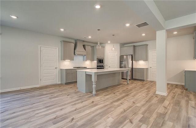 2516 Cadenza Cir, Dacula, GA 30019 - kitchen with gray cabinets, appliances with stainless steel finishes, premium range hood, light countertops, and recessed lighting