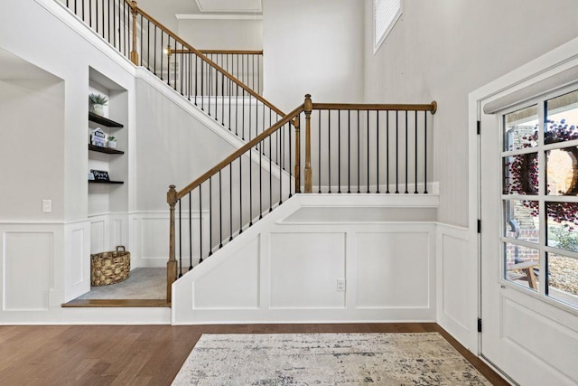 stairway featuring a high ceiling and hardwood / wood-style flooring