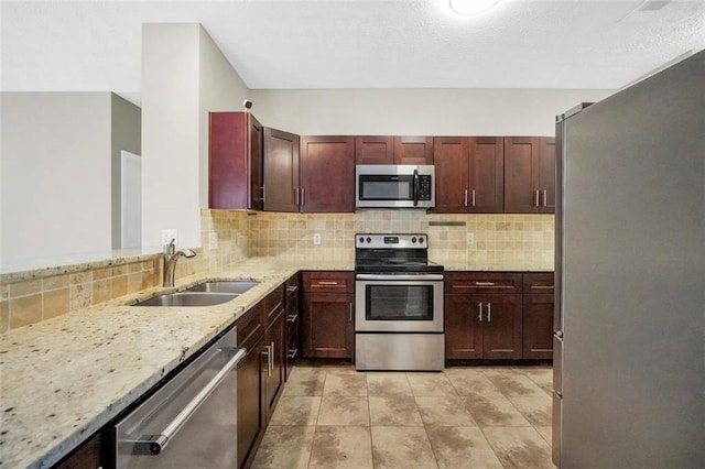 5600 Walnut Creek Ct NW, Lilburn, GA 30047 - kitchen with stainless steel appliances, a sink, light stone counters, decorative backsplash, and reddish brown cabinets