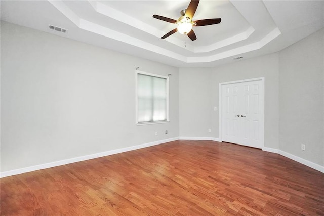 5600 Walnut Creek Ct NW, Lilburn, GA 30047 - empty room with a raised ceiling, ceiling fan, wood finished floors, and baseboards