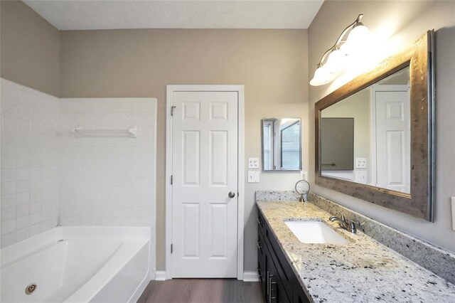 5600 Walnut Creek Ct NW, Lilburn, GA 30047 - full bathroom featuring wood finished floors, vanity, baseboards, and a combined bath / shower with jetted tub