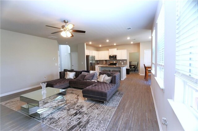 living room with ceiling fan and hardwood / wood-style flooring