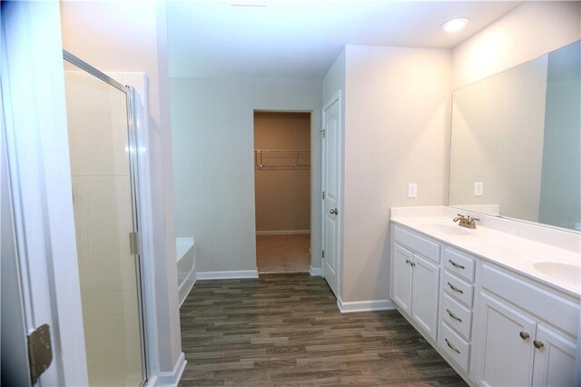 bathroom with a shower with shower door, vanity, and wood-type flooring