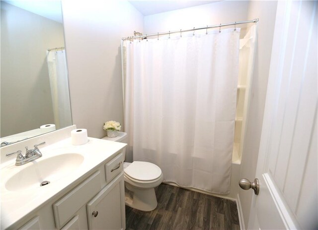 full bathroom featuring toilet, shower / bathtub combination with curtain, hardwood / wood-style floors, and vanity