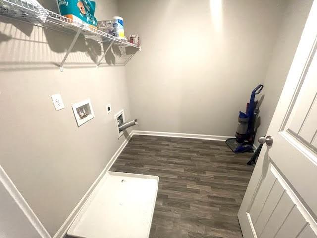 laundry room featuring dark wood-type flooring, hookup for a washing machine, and electric dryer hookup