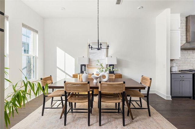 dining space with dark hardwood / wood-style flooring, a chandelier, and a wealth of natural light