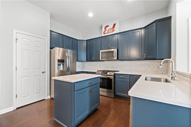 kitchen with appliances with stainless steel finishes, a center island, dark hardwood / wood-style flooring, and sink