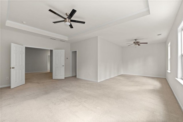 spare room featuring light carpet, a raised ceiling, ceiling fan, and crown molding