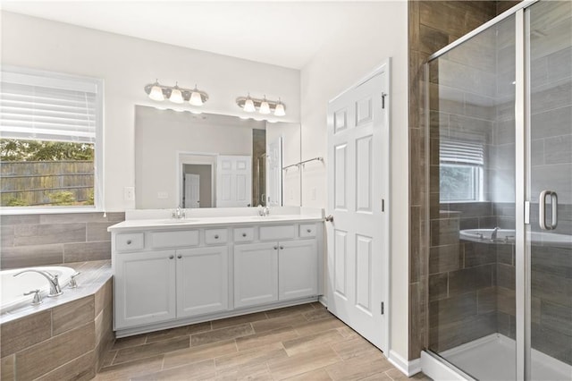 bathroom featuring vanity and independent shower and bath