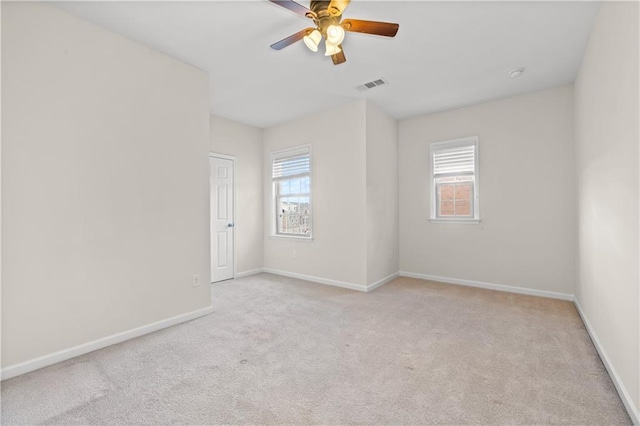 carpeted empty room featuring ceiling fan and plenty of natural light