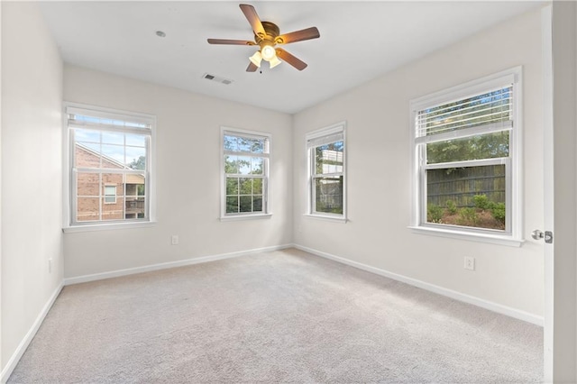 carpeted spare room featuring ceiling fan