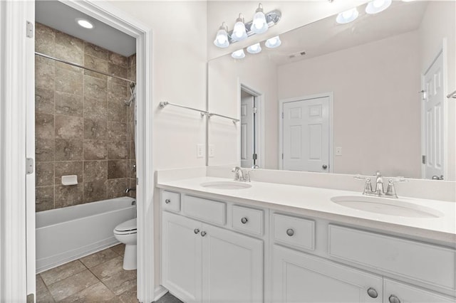 full bathroom with tile patterned flooring, vanity, toilet, and tiled shower / bath combo