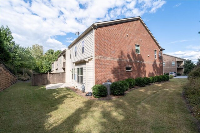 view of property exterior with a lawn and a patio