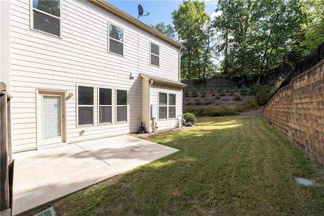 rear view of property featuring a balcony, a yard, and a patio