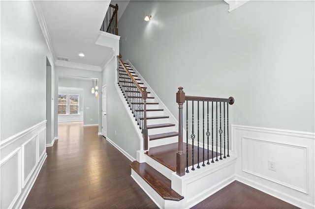 staircase with hardwood / wood-style floors and ornamental molding