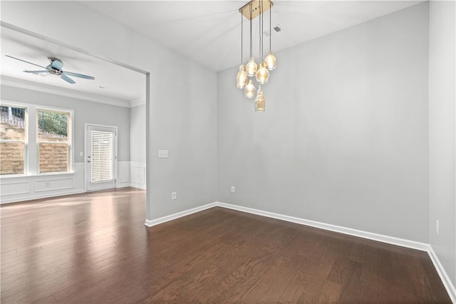 empty room featuring ceiling fan, ornamental molding, and dark wood-type flooring