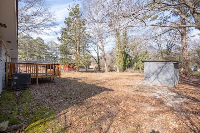 view of yard with a deck, cooling unit, and a shed